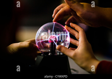 Los alumnos tocando una bolas de plasma aprender los principios de la ciencia física en una escuela general secundaria en Gales, Reino Unido Foto de stock