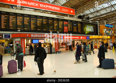 La estación Victoria, el hall principal, viajeros que buscan en la junta de salida, Londres, Inglaterra, Reino Unido, Europa Foto de stock