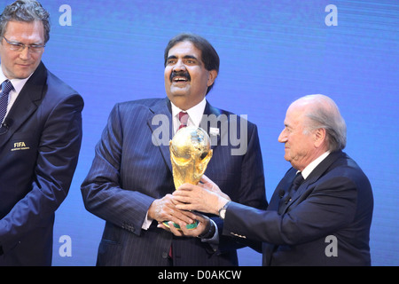 El Jeque Hamad bin Khalifa Al-Thani, Emir de Qatar, sostiene el trofeo de la Copa Mundial recibió del Presidente de la FIFA, Joseph Blatter (r)
