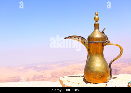 Cafetera árabe sobre la piedra y las montañas de Jordania en el fondo