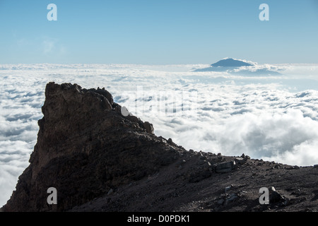 El monte Kilimanjaro, Tanzania - La cumbre del Monte Meru se mete a través de las nubes como se ve desde la flecha del glaciar del Monte Kilimanjaro Ruta Lemosho. Foto de stock