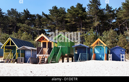 Algunas coloridas casetas de playa en pozos junto al mar Foto de stock
