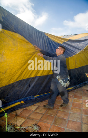 Los obreros hispanos en Laguna Niguel, CA, cubrir una casa con una carpa gasproof previo a la fumigación de las termitas la infestación. Foto de stock