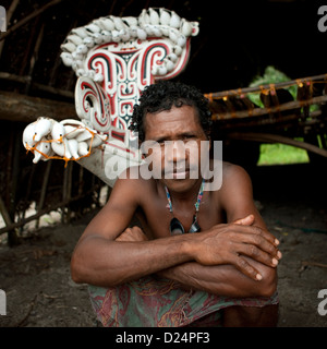 Marinero delante de Kula Canoa decorada con conchas, Islas Trobriand, Papua Nueva Guinea Foto de stock