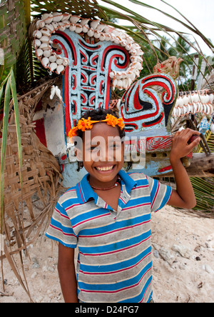 Niña delante de Kula Canoa decorada con conchas, Islas Trobriand, Papua Nueva Guinea Foto de stock