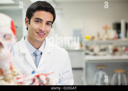 Retrato de sonriente científico con modelo anatómico n laboratorio