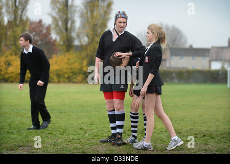 Una niña se une a un grupo de niños para un partido de rugby en Pates Grammar School en Cheltenham, Gloucestershire, Reino Unido Foto de stock