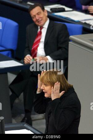 (Dpa) - La presidenta de la CDU, Angela Merkel, gestos como ella habla en el Bundestag (Cámara Baja del Parlamento alemán), observados por el canciller Schroeder, Berlín, 4 de diciembre de 2002. Merkel dijo Schroeder no era apropiado para las tareas necesarias.