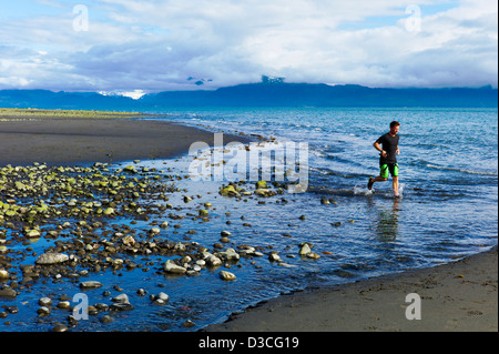 Hombre corriendo duro en Obispo Playa, Homer, Alaska, EE.UU. Foto de stock