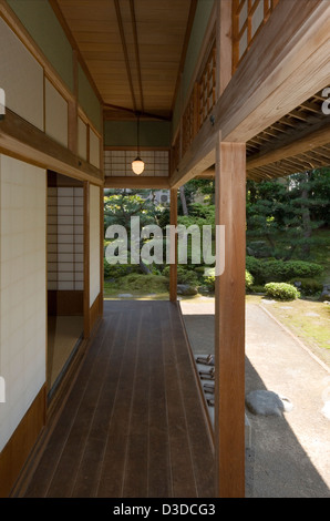 Mirador de madera cubierto abierto a la soleada vista del jardín japonés en casa samurai Uchiyamake Bukeyashiki Kyu, Echizen-Ono, Fukui Foto de stock