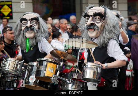 Dos locos disfraces Gugge músicos tocando los tambores en el carnaval de Basilea Foto de stock