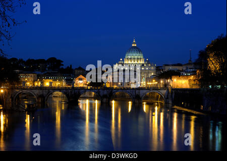 Italia, Roma, el río Tíber, el puente de Sant'Angelo y la basílica de San Pedro por la noche Foto de stock