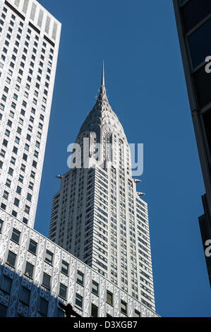 Mirando hacia arriba desde el nivel de la calle en Nueva York del edificio Chrysler entre rascacielos cercanos.