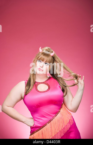 Retrato de mujer vestida como un demonio, con cuernos de diablo divirtiéndose y goofing alrededor.