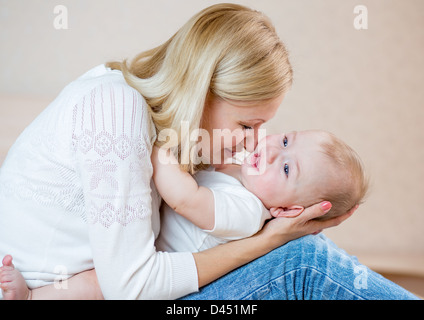 Madre jugando con baby boy aislado en blanco