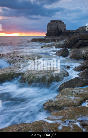 Las olas chocan contra la costa rocosa de Portland Bill al atardecer. Isla de Pórtland, Dorset, Inglaterra. La primavera (abril) de 2012.