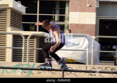 Israel, Tel Aviv, Yad Eliyahu, Urban extreme sport park. Macho joven realizando acrobacias con roller blades Foto de stock