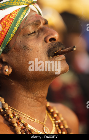 Devoto hindú fumar cigarro Thaipusam anual festival religioso en las Cuevas Batu, cerca de Kuala Lumpur, Malasia. Foto de stock