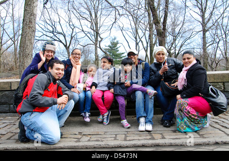 Retrato de Hispanic amigos sentado en un banco del parque en Central Park, Manhattan, Ciudad de Nueva York, EE.UU.. Foto de stock