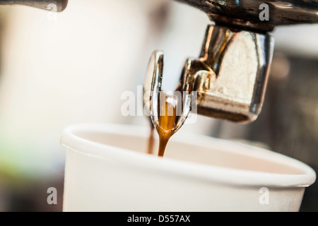 Verter el espresso en la cubeta de la máquina Foto de stock
