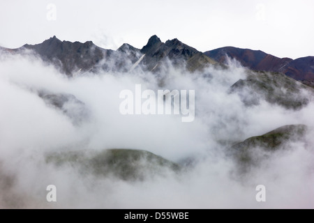 Las nubes bajas, niebla y niebla oscura parcialmente la Cordillera de Alaska, el Parque Nacional Denali, Alaska, EE.UU. Foto de stock