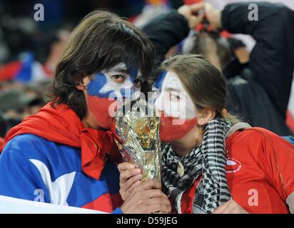 Dos partidarios de Chile kiss una maqueta trophy en el stand antes de la Copa Mundial de la FIFA 2010 Grupo H partido entre Chile y España en el estadio Loftus Versfeld en Pretoria, Sudáfrica, 25 de junio de 2010. Foto: Marcus Brandt dpa - Consulte http://dpaq.de/FIFA-WM2010-TC +++(c) dpa - Bildfunk+++