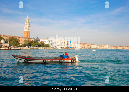 Barco de pesca, pasando por delante de la torre campanario en el gran canal de Venecia, Italia