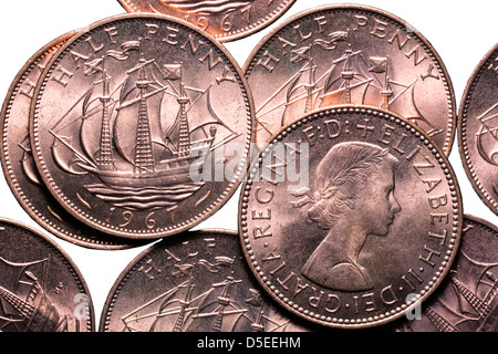 Montón de monedas de medio centavo, UK, sobre fondo blanco.