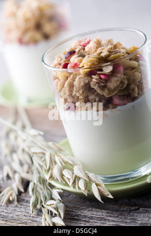 Yogur natural con granola en vaso pequeño Foto de stock