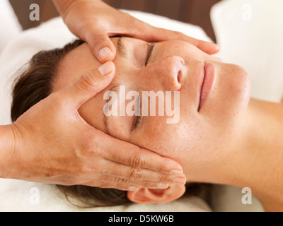 Mujer recibiendo un masaje facial en el spa Foto de stock