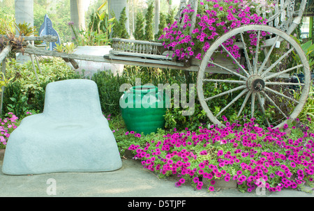 Jardín de flores coloridas Silla de madera antigua Tailandia Foto de stock