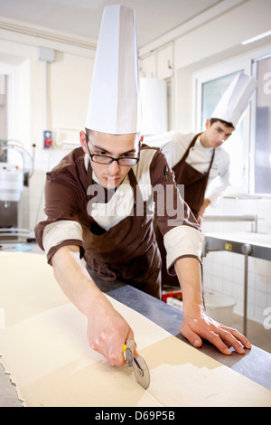Baker cortando la masa en la cocina