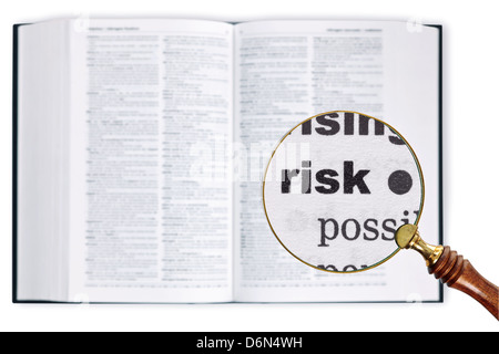 Una lupa celebradas durante un diccionario buscando la palabra riesgo ampliado Foto de stock