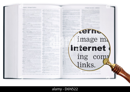 Una lupa celebradas durante un diccionario buscando la palabra Internet agrandamiento Foto de stock