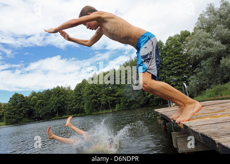 Emstal, Alemania, el muchacho salta en el agua de la piscina Foto de stock