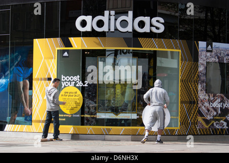 Tienda Adidas Oxford Londres, trabajador pega hacia el exterior de la tienda Fotografía de stock - Alamy