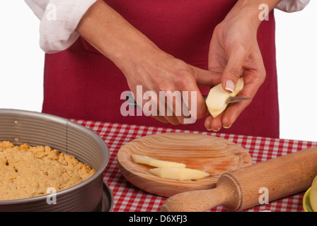 Manos femeninas cortando manzanas mientras preparaba un pastel Foto de stock