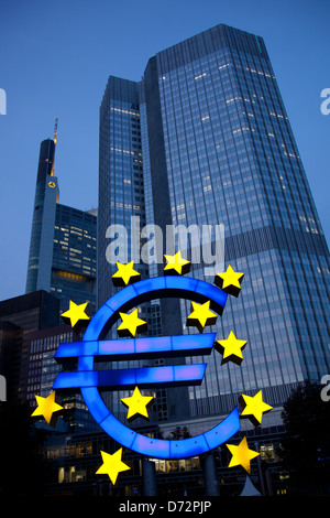 Frankfurt, Alemania, se ilumina el euro escultura delante de la torre del BCE euro Foto de stock