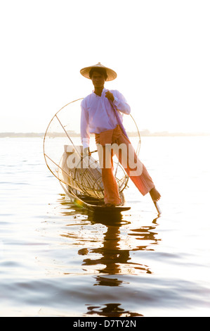 Pierna Intha pescadores remando al atardecer en el Lago Inle, Lago Inle, el Estado de Shan, Birmania Foto de stock