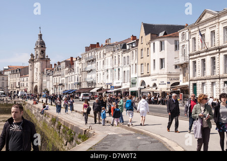 La gente camina a lo largo de la orilla del mar en el puerto de La Rochelle, Francia Foto de stock