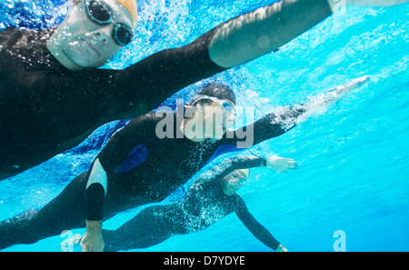 Triatletas en wetsuits underwater