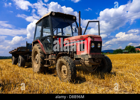 Red tractor viejo en verano en el campo Foto de stock