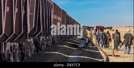 La gente espera a subir al tren del mineral de hierro en Nouadhibou, Mauritania