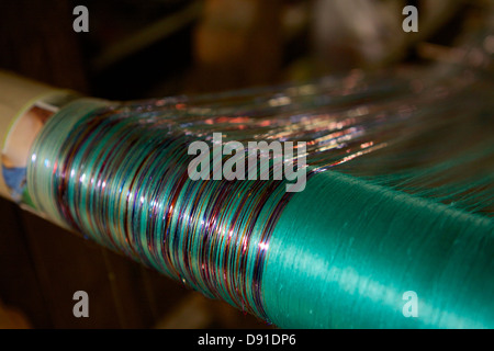 Hilos de seda se mano tejida en un telar de madera tradicional en la localidad de Amarapura, conocida por su industria textil Foto de stock