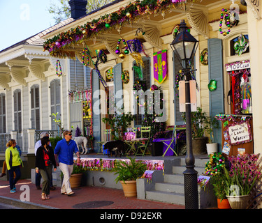 Los turistas pasan por una casa decorada por Mardi Gras en Nueva Orleáns Foto de stock