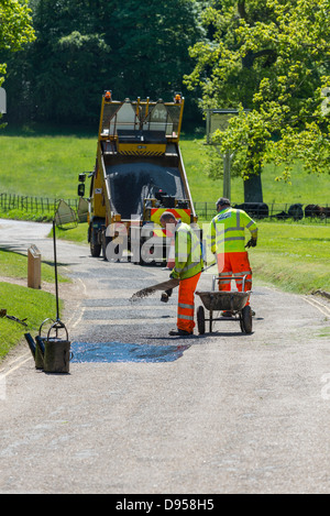 Los obreros reparen los daños en la superficie de la carretera, Norfolk, Inglaterra, junio Foto de stock