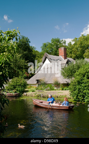Un par visto canotaje en el Río Stour por una cabaña en Dedham. Foto de stock