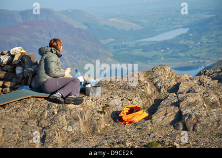 Un excursionista femenina teniendo en opinión de Loweswater y Crummock agua desde la cumbre de Robinson en el Lake District Foto de stock