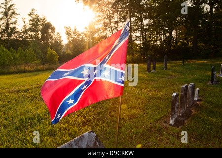 Ondear la bandera confederada en el viento en un antiguo cementerio del sur Foto de stock