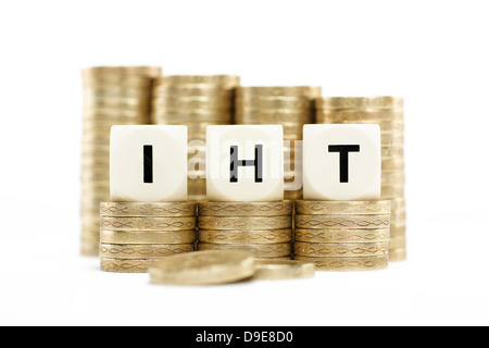 IHT (impuesto a la herencia) en pilas de monedas de oro sobre un fondo blanco. Foto de stock